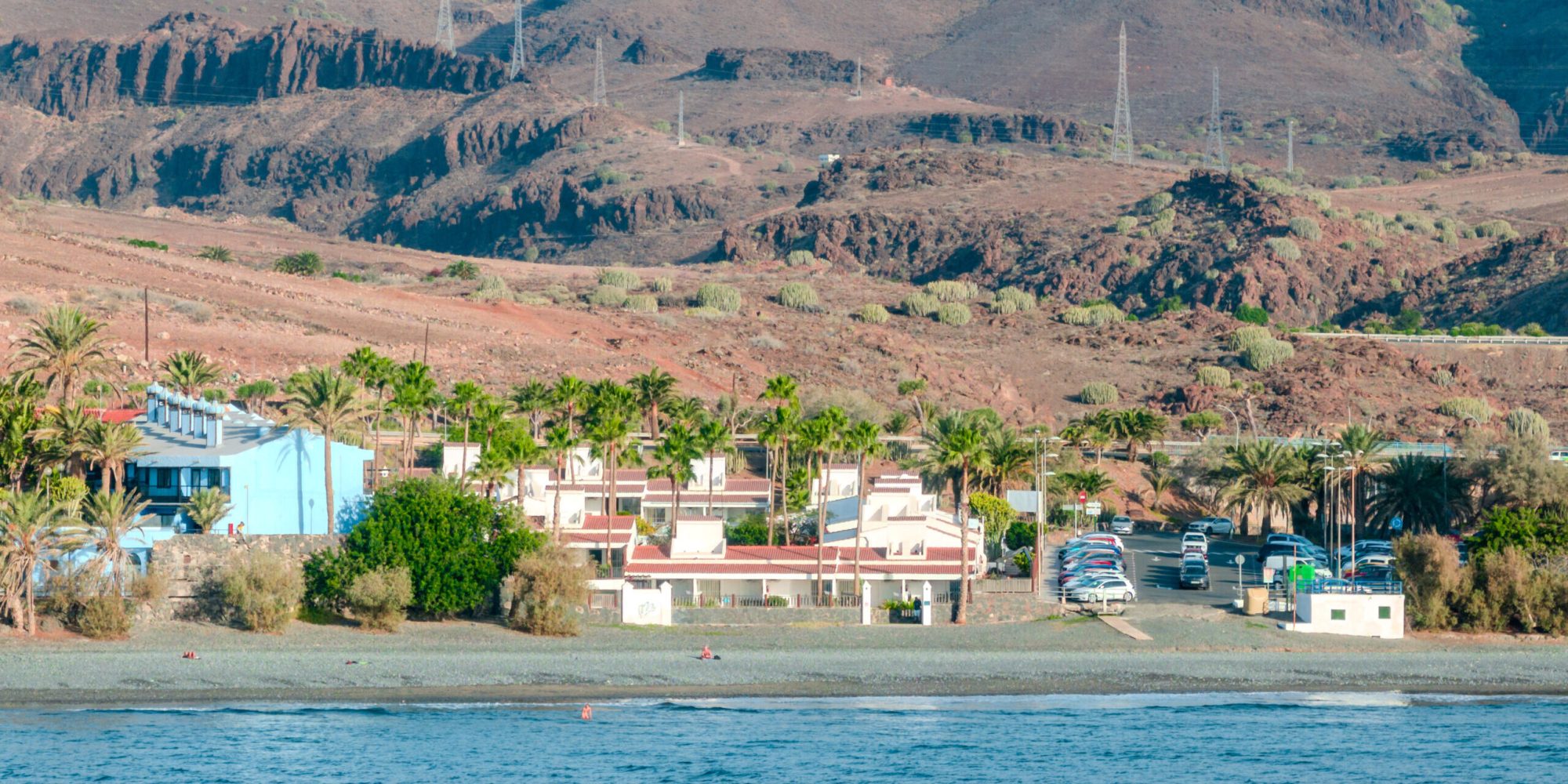 Dronebilde av Makāi Bungalows på Gran Canaria, omgitt av fjell og nær havet